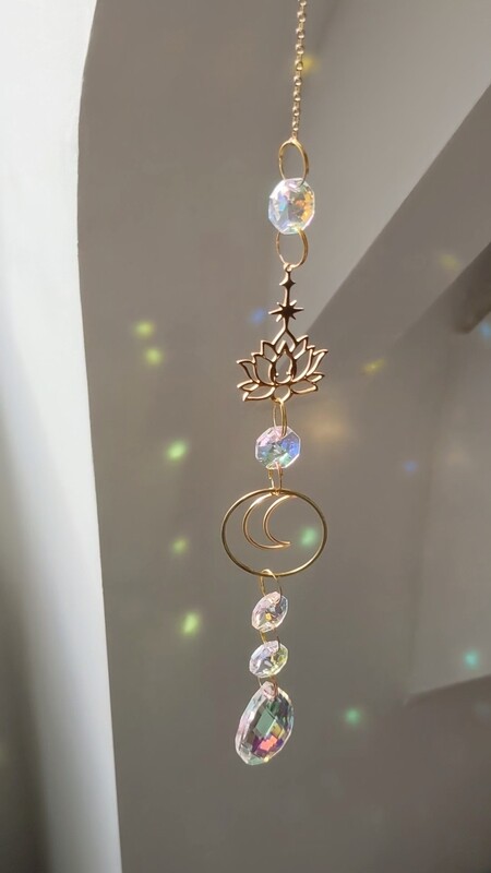 Attrape soleil fait main en pièce unique ou petite série, composé de matériaux durables de qualité. Objet de décoration Feng Shui, l&#39;attrape soleil, invite à l&#39;intérieur de votre maison toutes les belles énergies du soleil en créant un arc-en-ciel lumineux plein de douceur et de magie. Il réharmonise et protège votre intérieur. Lotus et lune