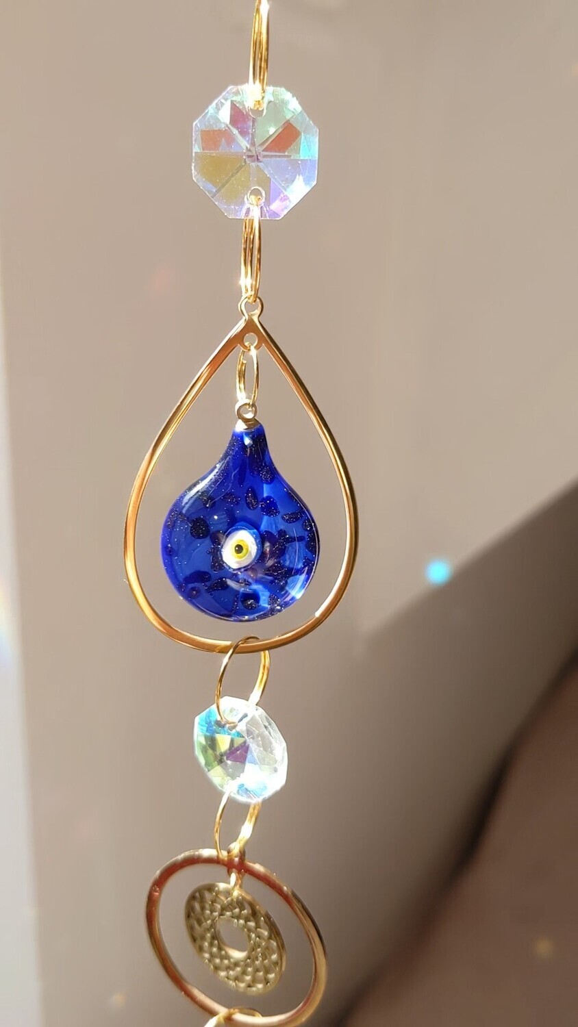 Attrape soleil fait main en pièce unique ou petite série, composé de matériaux durables de qualité.  Nazar en verre tout droit venu d&#39;Istanbul. Objet de décoration Feng Shui, l&#39;attrape soleil, invite à l&#39;intérieur de votre maison toutes les belles énergies du soleil en créant un arc-en-ciel lumineux plein de douceur et de magie. Il réharmonise et protège votre intérieur.
