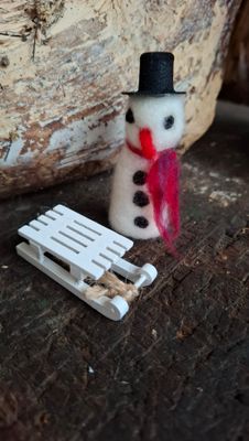 Nadelgefilzter Miniatur Schneemann mit kleinem Schlitten