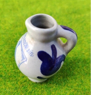 Miniatur Bembel aus Steinzeug, 4,5 cm hoch, bemalt mit Steinheim am Main Motiv auf grüner Grasmatte.