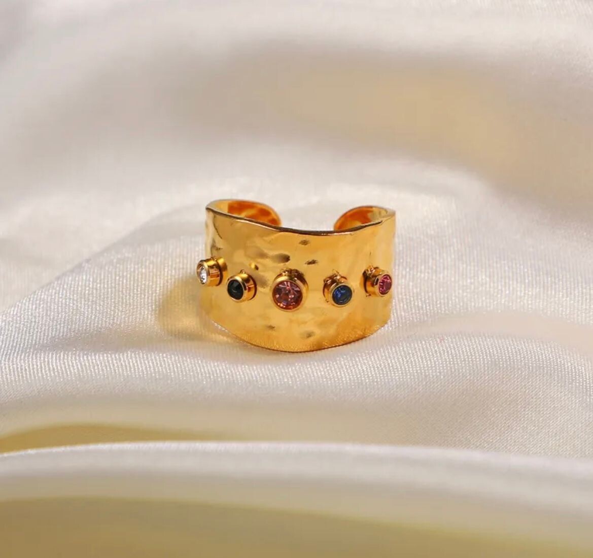 Gold adjustable ring with different coloured gems.