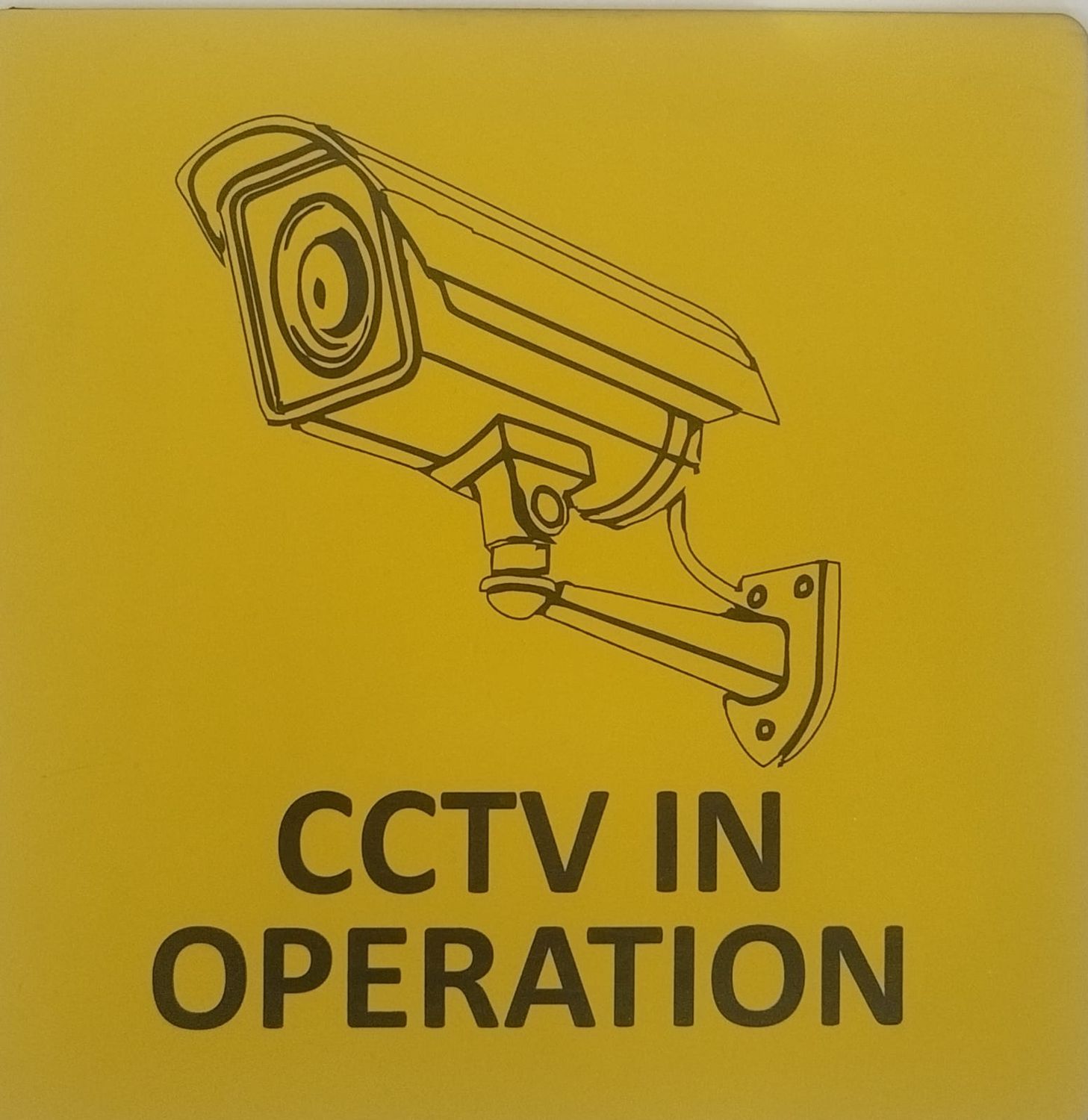 Sign "CCTV" in yellow with black engraved text and image