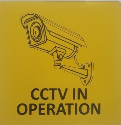 Sign "CCTV" in yellow with black engraved text and image