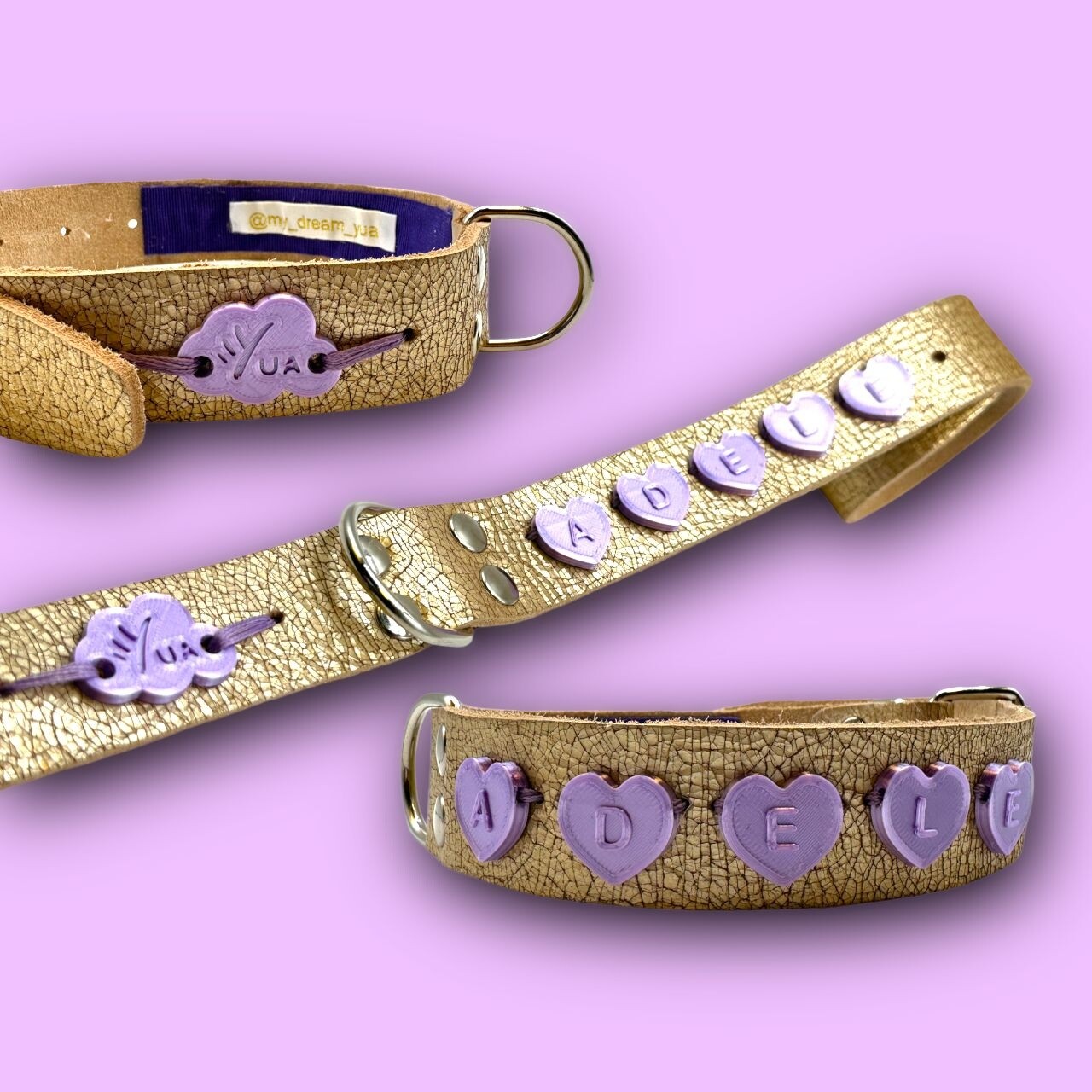 COLLARE in pelle martellata color oro senza bordatura personalizzato con charme per il nome AGNESE a forma di cuori color lilla in PLA. La taglia del collare è la M. COLLARE in pelle martellata color oro senza bordatura personalizzato con charme per il nome AGNESE a forma di cuori color lilla in PLA. La taglia del collare è la M.