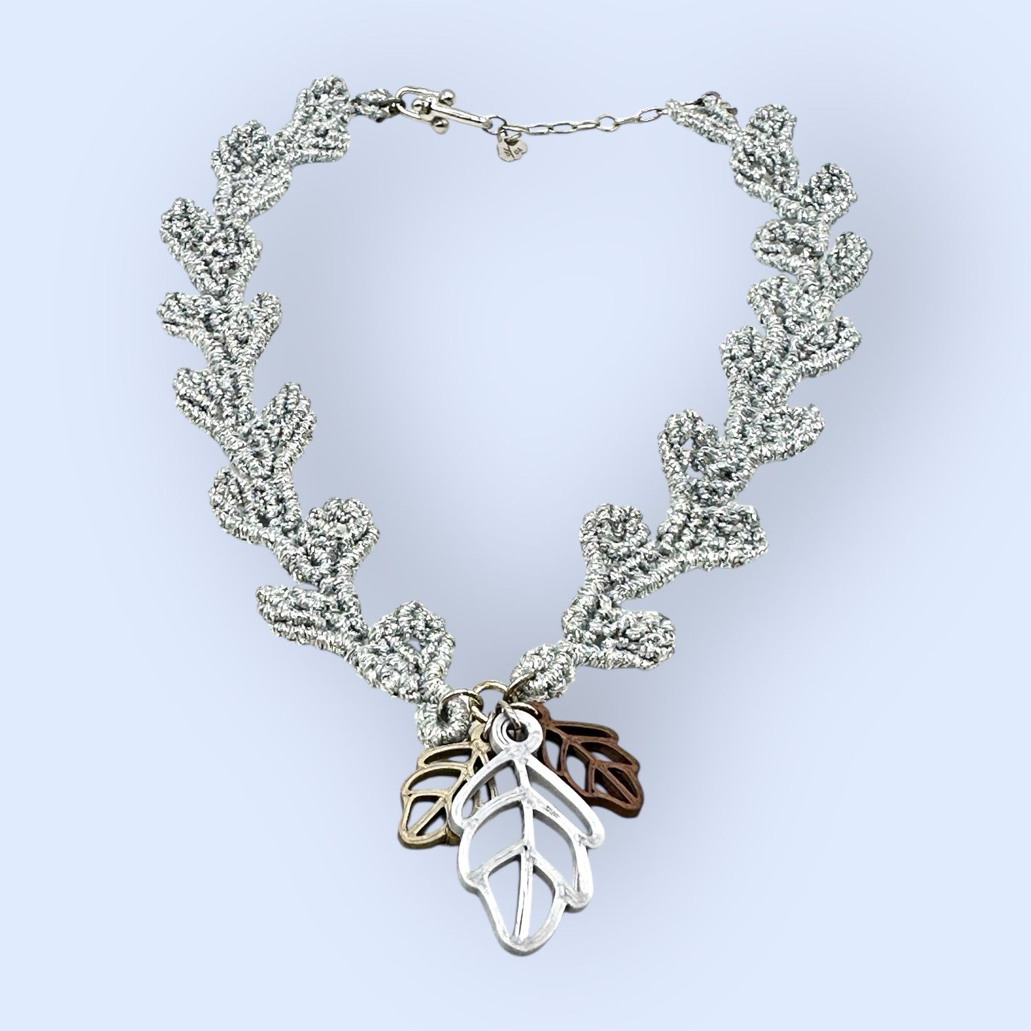 Girocollo con foglioline in macramè filato argento, rifinito in argento e personalizzato con foglioline in PLA di diversi colori.