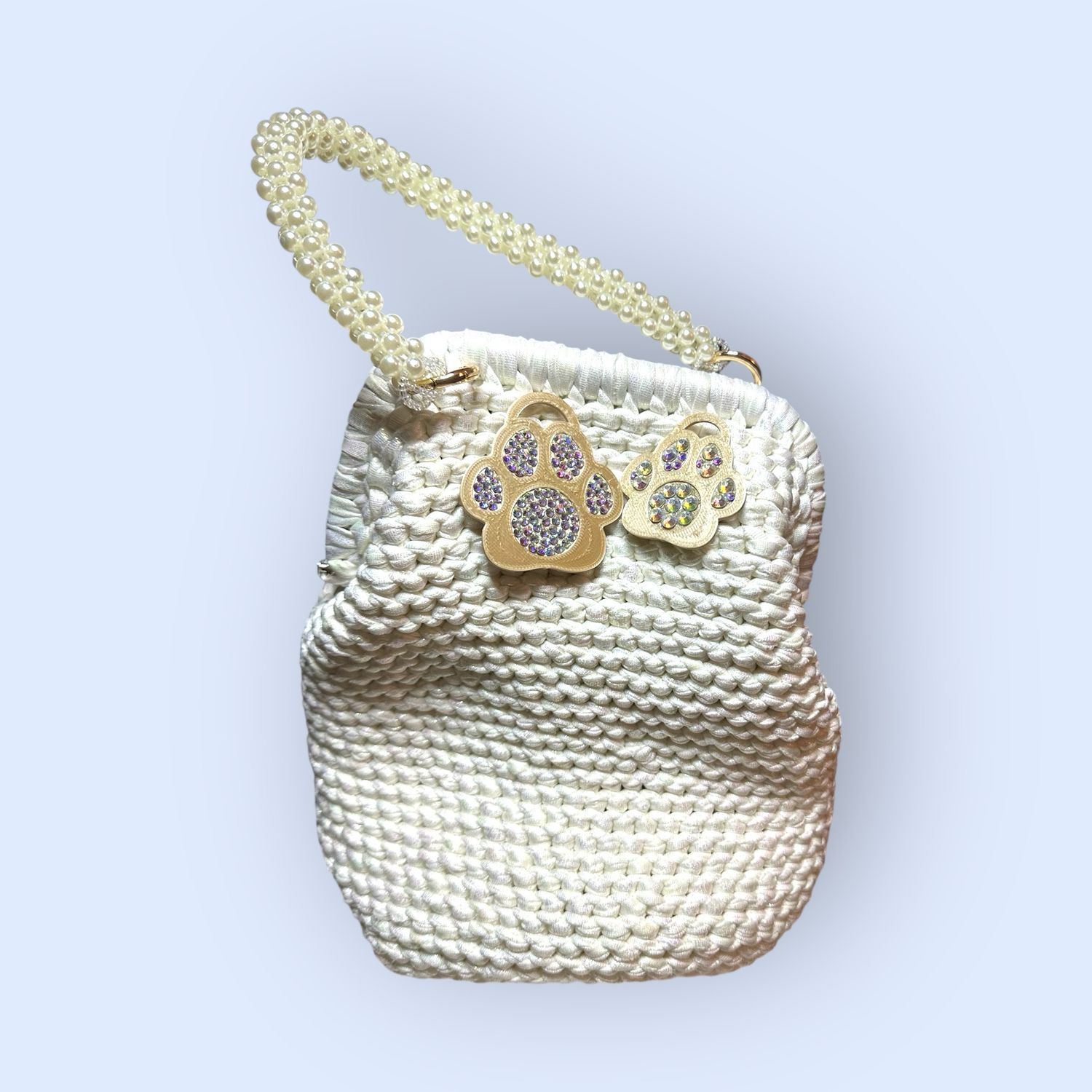 Borsa realizzata all’uncinetto con filato similpelle color bianco personalizzato con zampette in PLA impreziosite di strass