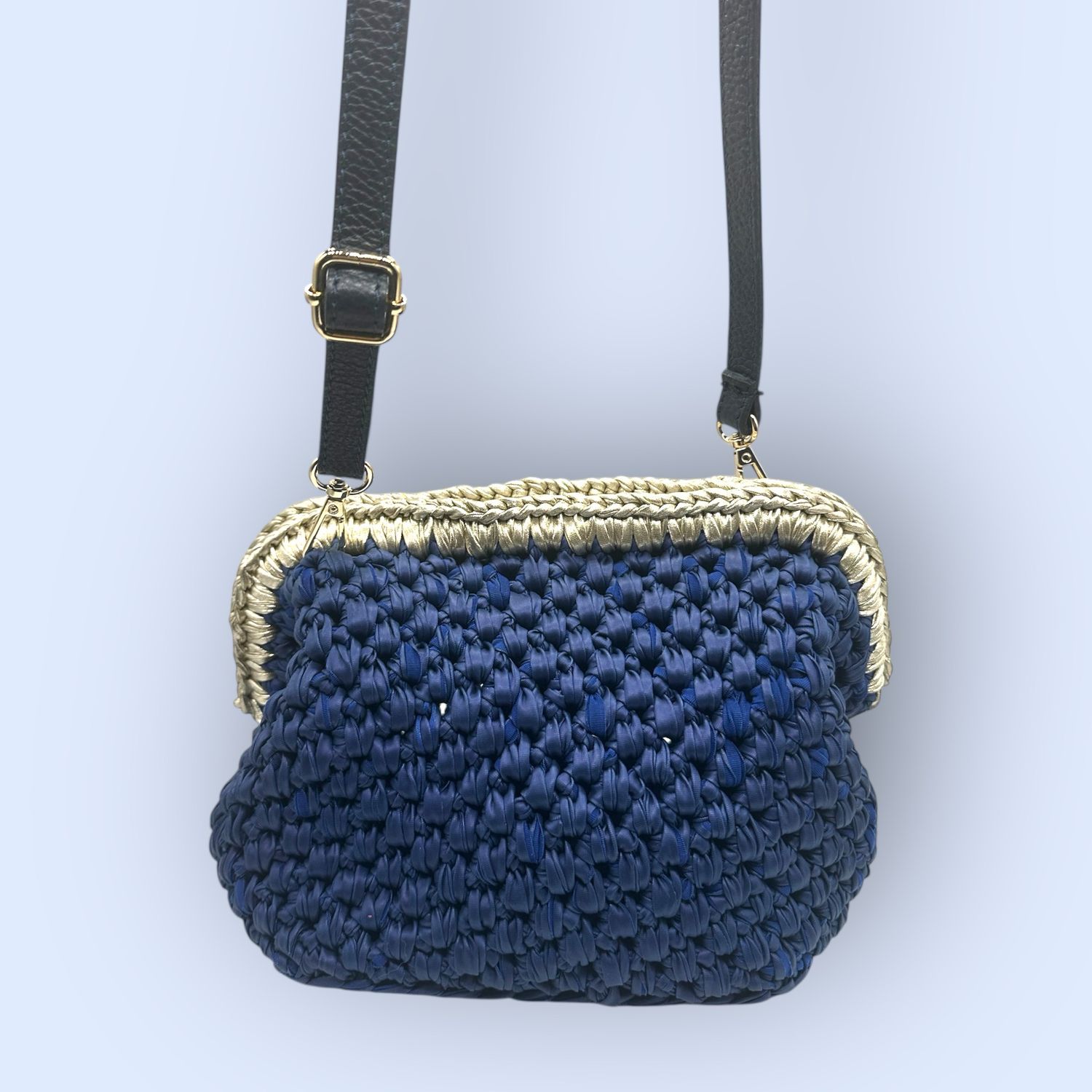 Borsa realizzata all’uncinetto con filato in ecopelle blu e oro personalizzata con charme in PLA a forma di foglia
