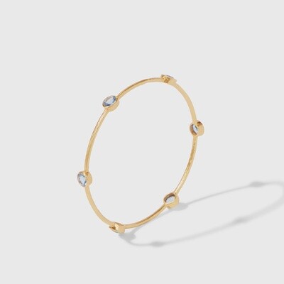 Julie Vos Milano bangle in 24-karat gold with hammered texture and embedded gemstones, worn on wrist in lifestyle setting