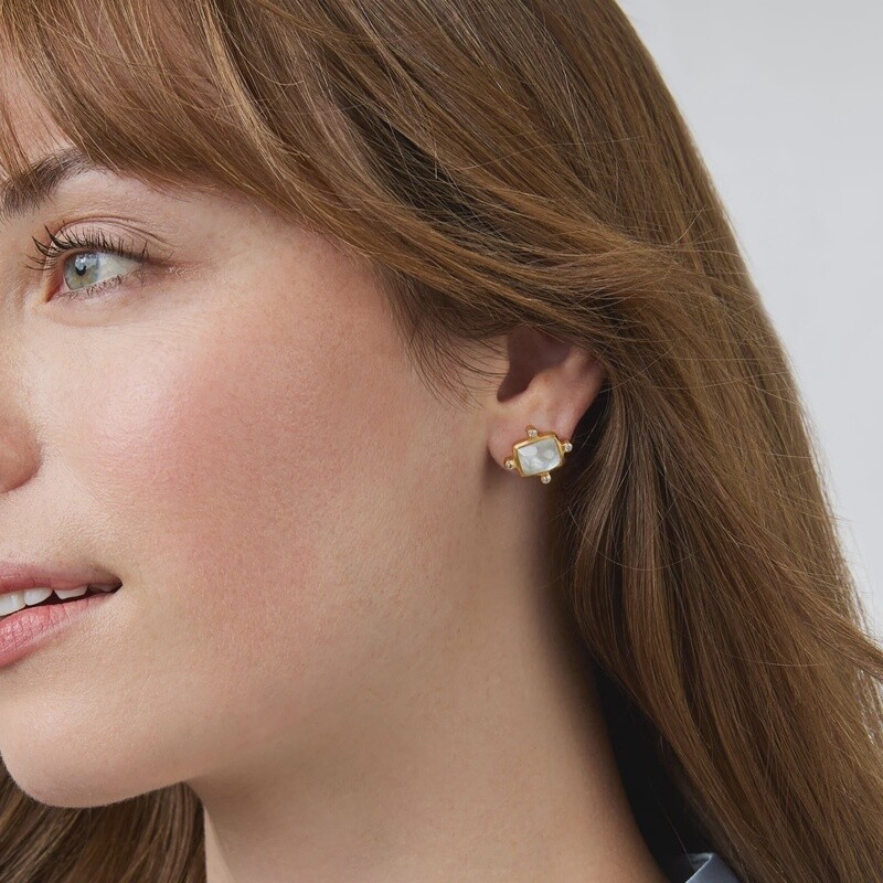 Clara stud earrings in 24K gold with cubic zirconia and mother of pearl, worn in a lifestyle setting