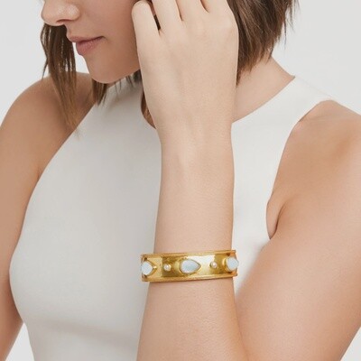 Julie Vos Cannes wide hinge bangle in 24K gold with a faceted pear-shaped gemstone, shown on wrist in lifestyle setting
