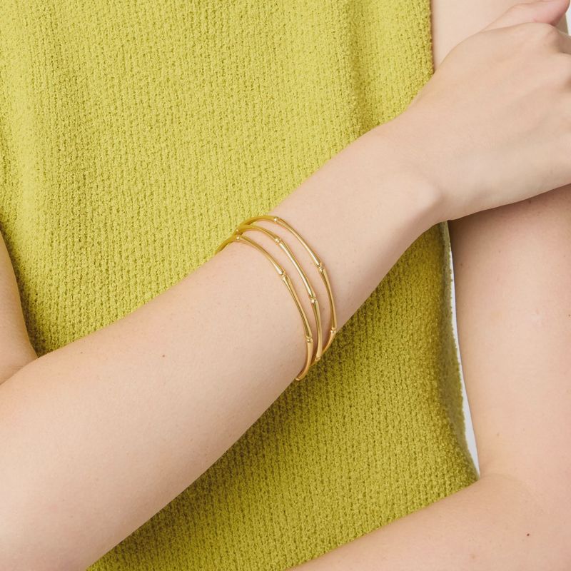 Julie Vos Bamboo Bangle in 24K gold plate worn on wrist in lifestyle setting