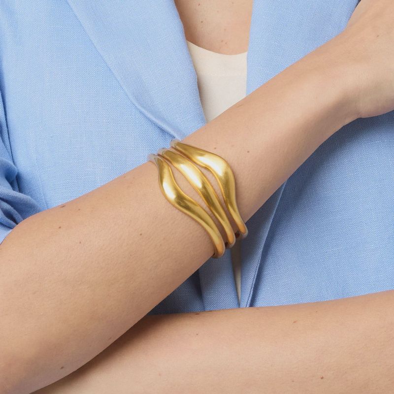 Julie Vos Wave Cuff bracelet in 24K gold-plated finish worn on wrist in lifestyle setting