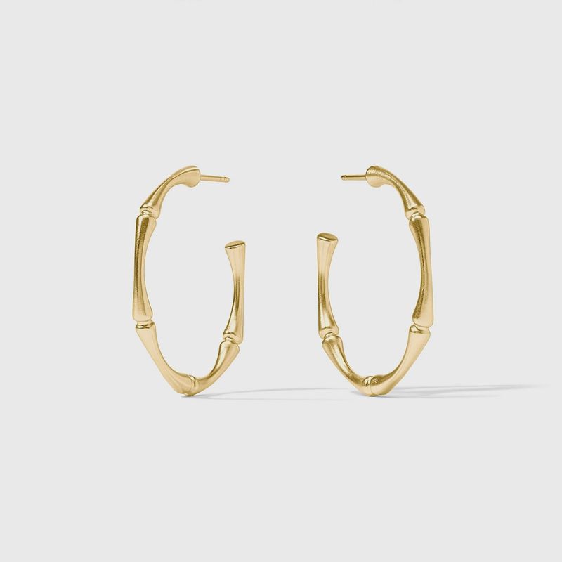 Julie Vos bamboo hoop earrings in 24k gold plate, shown in three sizes, worn in a lifestyle setting