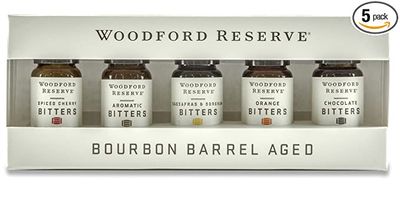 Five 10ml bottles of Woodford Reserve bitters in a sampler set arranged on a white background, featuring various bitters varieties in glass bottles with labeled caps