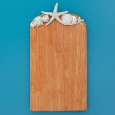Large birch wood cutting and serving board with hand-carved shell and starfish design on a white background