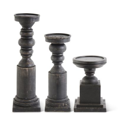 Pair of black wood candleholders with square bases on a neutral background