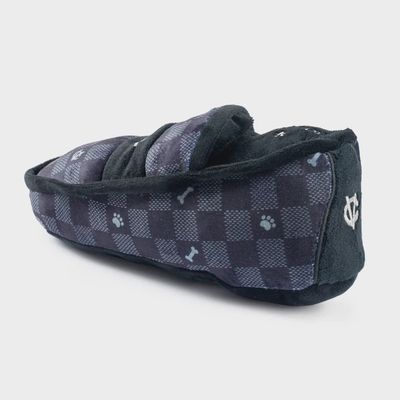 Black and white checkered plush dog loafer toy with woven texture detail on a neutral background
