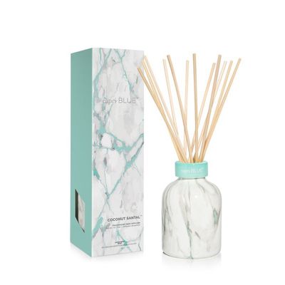 Capri Blue Coconut Santal petite reed diffuser with modern marble base and natural rattan reeds on white background