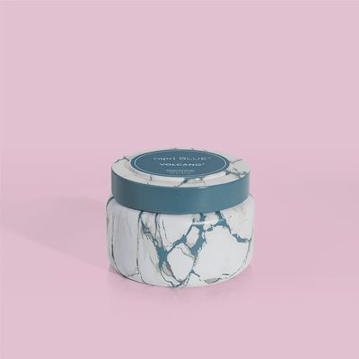 Capri Blue Volcano candle in a modern marble-patterned travel tin, 8.5 oz size, on neutral background