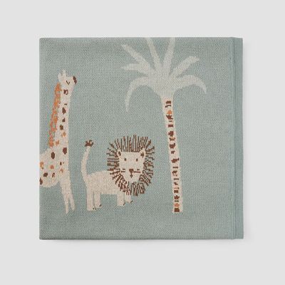 Safari lion jacquard knit baby blanket in cream and tan, displayed flat in studio lighting showing woven texture and pattern detail