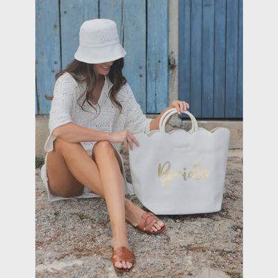 Ivory tote bag with scalloped edge detailing and magnetic snap closure, displayed in a lifestyle setting