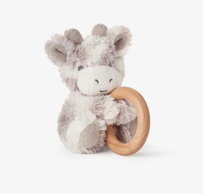 Plush giraffe sensory toy with natural wood ring rattle attached, featuring soft tan fabric and wooden teething ring on white background