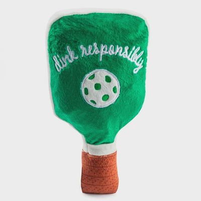 Green and white striped pickleball paddle squeaker toy by Haute Diggity Dog in a lifestyle setting