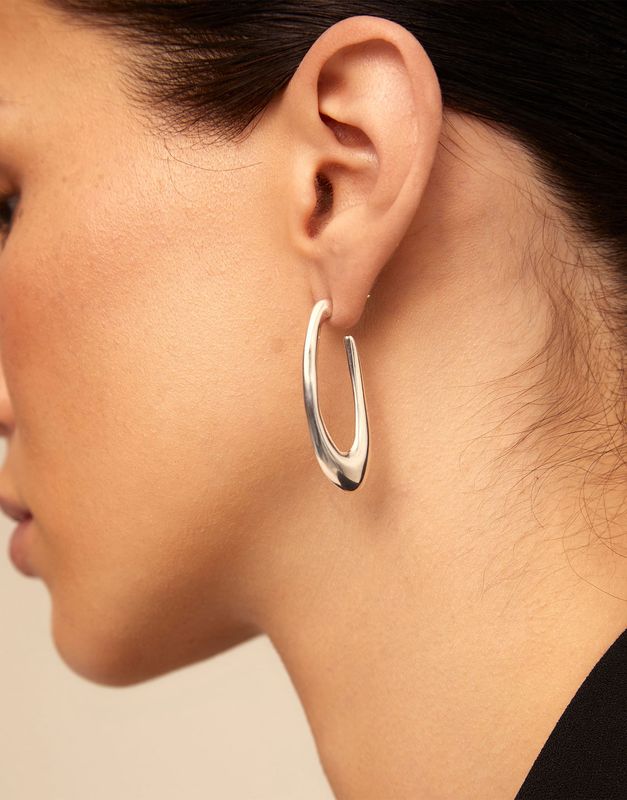 Silver-plated oval earrings from Uno de 50's Do You Orbit collection worn in a lifestyle setting