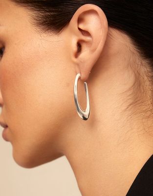 Silver-plated oval earrings from Uno de 50's Do You Orbit collection worn in a lifestyle setting