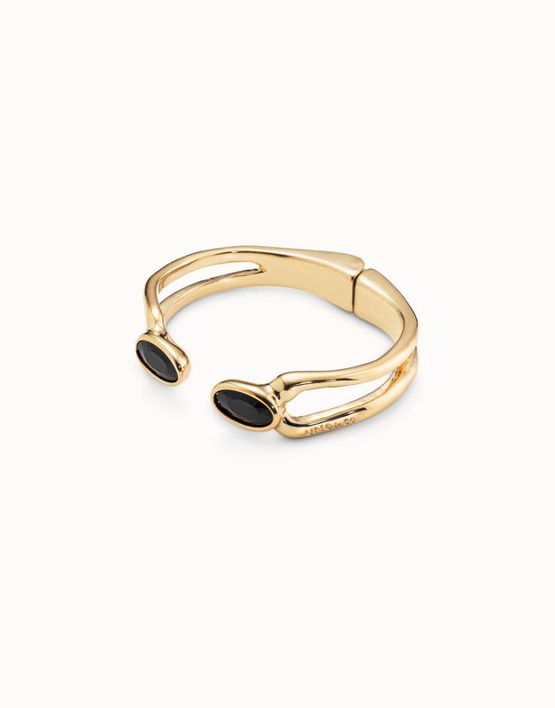 Gold-plated open bracelet with black crystal stones worn on wrist in lifestyle setting