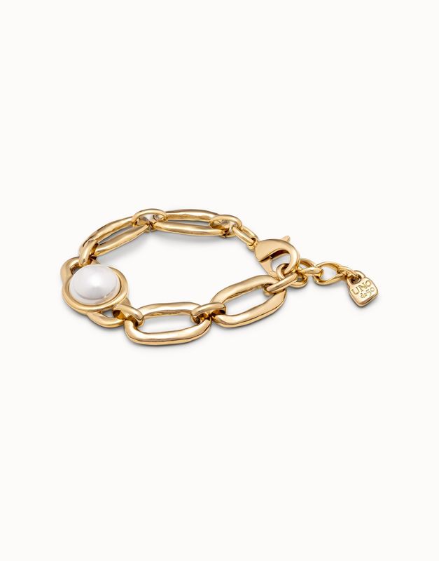 Gold-plated Uno de 50 Ovni bracelet with pearl link details worn on wrist against neutral background