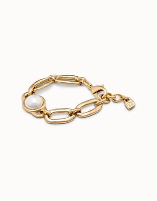 Gold-plated Uno de 50 Ovni bracelet with pearl link details worn on wrist against neutral background