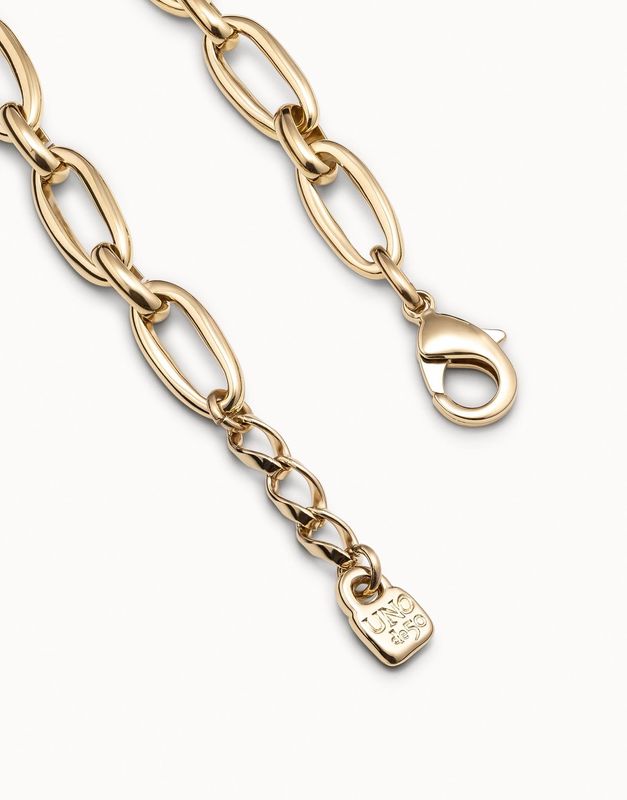 Gold-plated oval link bracelet by Uno de 50 worn on wrist in lifestyle setting