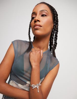 Sterling silver-plated hinged dragonfly bracelet from Uno de 50's Ser Rebelde collection, displayed against a neutral background