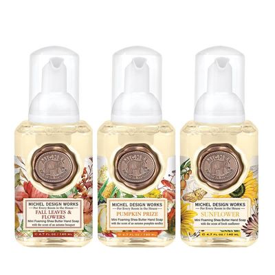 Three mini foaming hand soap bottles from Michel Design Works Autumn Scents collection arranged on white background