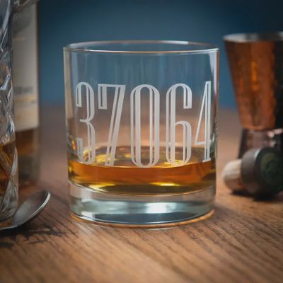 11-ounce whiskey rocks glass with sand-carved zip code engraving, isolated on white studio background