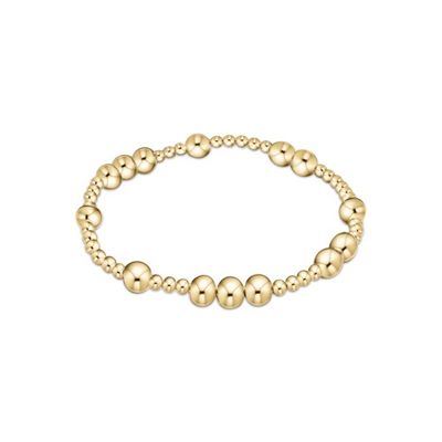 Gold beaded bracelet with 6mm spheres and small engraved charm on white background