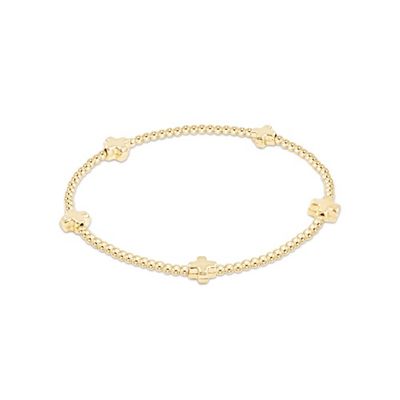 ENEWTON Signature Cross Small 2mm gold bracelet displayed on a neutral background, showing the delicate cross charm and beaded design