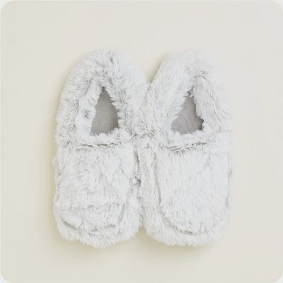 Lavender marshmallow-textured slippers on feet in a cozy indoor setting, showing soft plush material and relaxed fit.