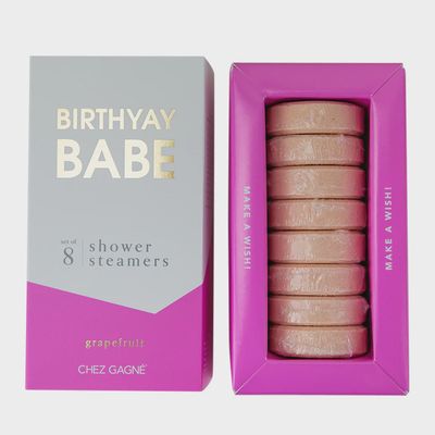 Set of eight grapefruit-scented shower steamers in pink and white packaging arranged on a white background