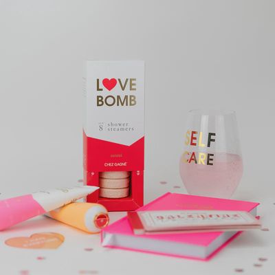 Love Bomb Santal aromatherapy shower steamers by Chez Gagne arranged in a spa-like bathroom setting with steam and soft lighting