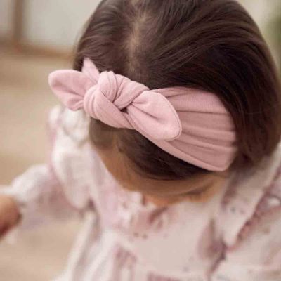 Four soft knot headbands in neutral colors displayed on a white surface, sized for newborns to 12 months