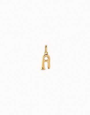 Uno de 50 handmade alphabet initial charm in 18K gold plating, isolated against white background in studio lighting