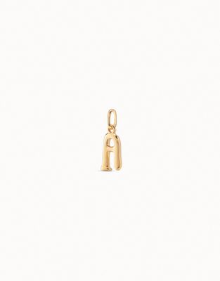 18K gold-plated alphabet initial charm by Uno de 50, handmade, displayed in a lifestyle setting with natural lighting