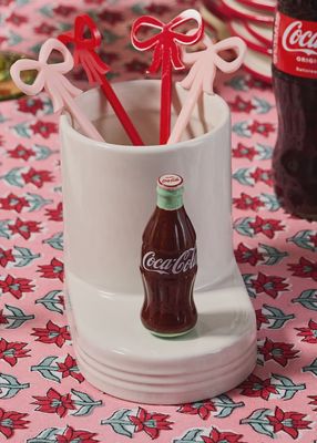 Nora Fleming Coke bottle mini decorative piece displayed on a tabletop in a home setting.