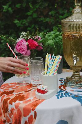 Nora Fleming Ice Cold mini cooler displayed in an outdoor entertaining setting with natural lighting