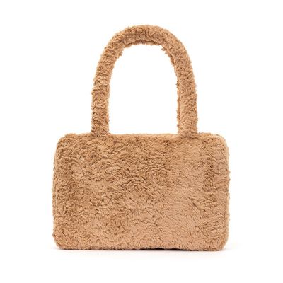 Jellycat Bartholomew Bear Tote Bag with plush fur handles and zip closure displayed in a lifestyle setting