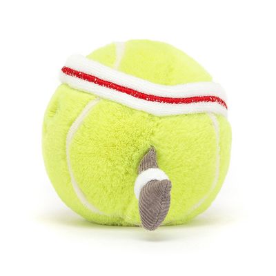 Jellycat Amuseable plush tennis ball with green headband and wristbands, posed on a neutral surface in a lifestyle setting