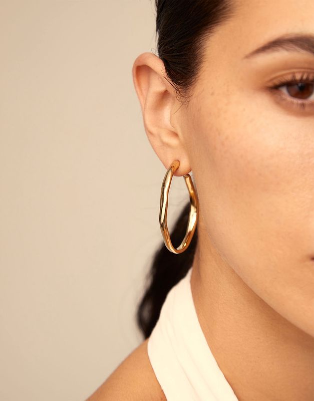 Silver-plated open hoop earrings from Uno de 50 worn in a lifestyle setting