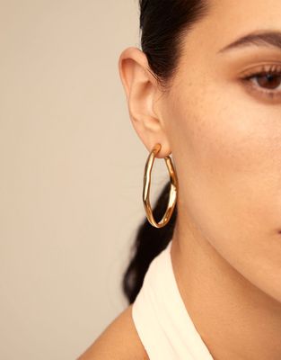 Silver-plated open hoop earrings from Uno de 50 worn in a lifestyle setting